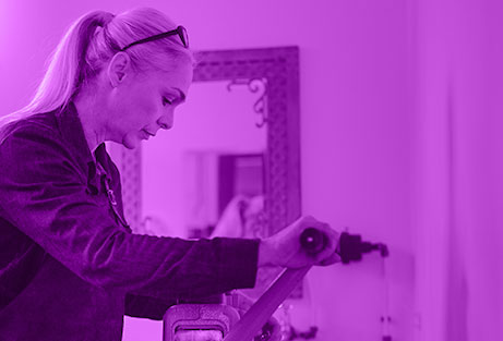 Goldsmith crafting gold on a manual machine