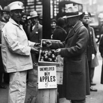 Unemployed man selling apples on the street, circa 1930.